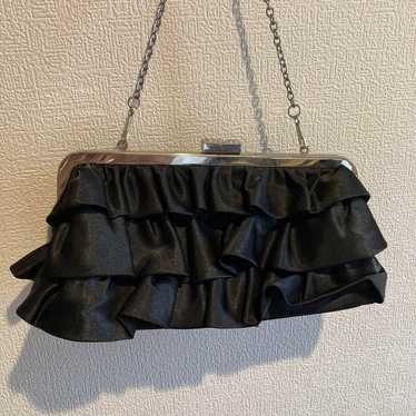 Black satin clutch bag with frills.