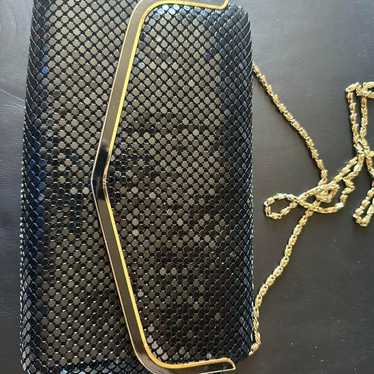 Black mesh clutch bag with gold hardware.