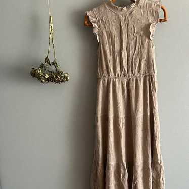 Beige sleeveless long one-piece dress.