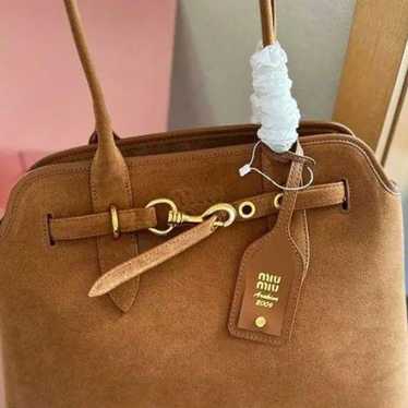 This is a MiuMiu suede shell bag.