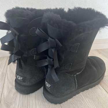 UGG Australia black sheepskin boots with ribbons.