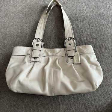 COACH cream-colored leather handbag.