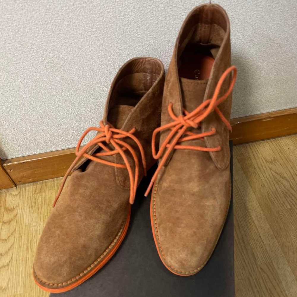 Brown suede chukka boots with orange laces. - image 1