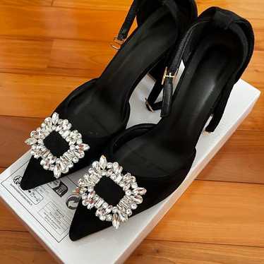 Black high heels with embellishments.