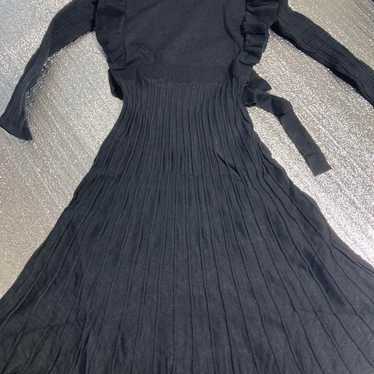 High-waisted black knit dress with frills.