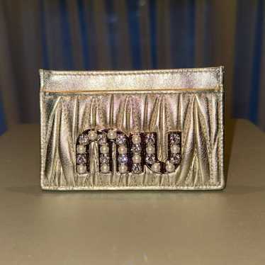 美品✨ミュウミュウ♡二つ折り財布　クリスタルリボン　シボ革　グレー　ゴールド金具 ゴールド（金色）系 MiuMiu(ミュウミュウ) 折りたたみ財布