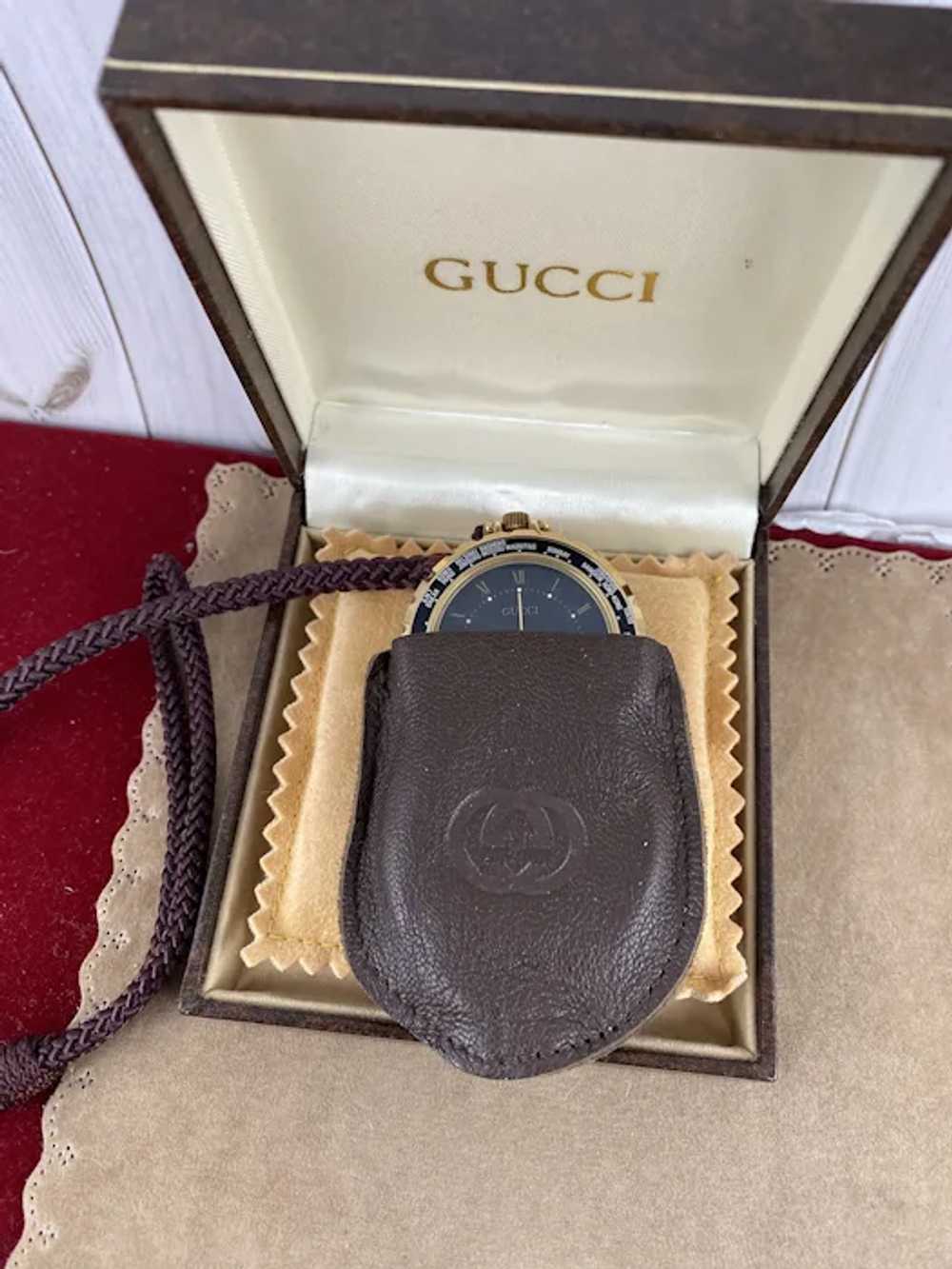 Lot consisting of Gucci vintage leather table clock and …