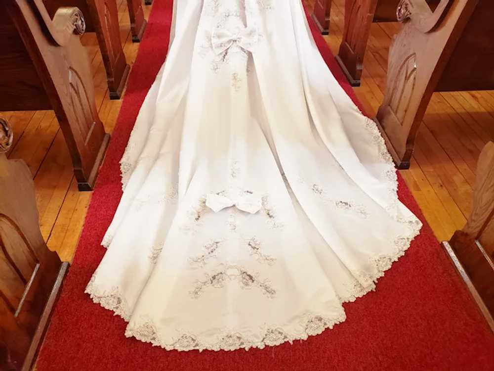 https://img.gem.app/678938491/5f/1682206561/pearls-bows-and-lace-stunning-satin-wedding-dress.jpg